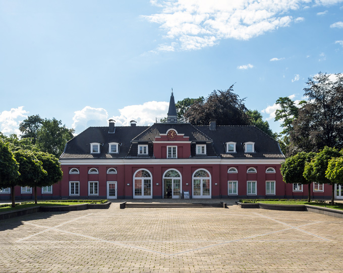 Schloss Oberhausen mit gepflastertem Vorplatz vor bewölktem Himmel